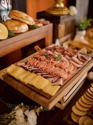 A beautifully arranged charcuterie board featuring cold meats, cheeses, and bread, ideal for weddings or events.