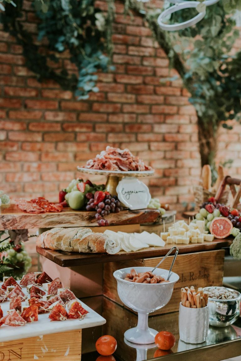 Elegant buffet display featuring cheese, cured meats, and fruits on a rustic setup.