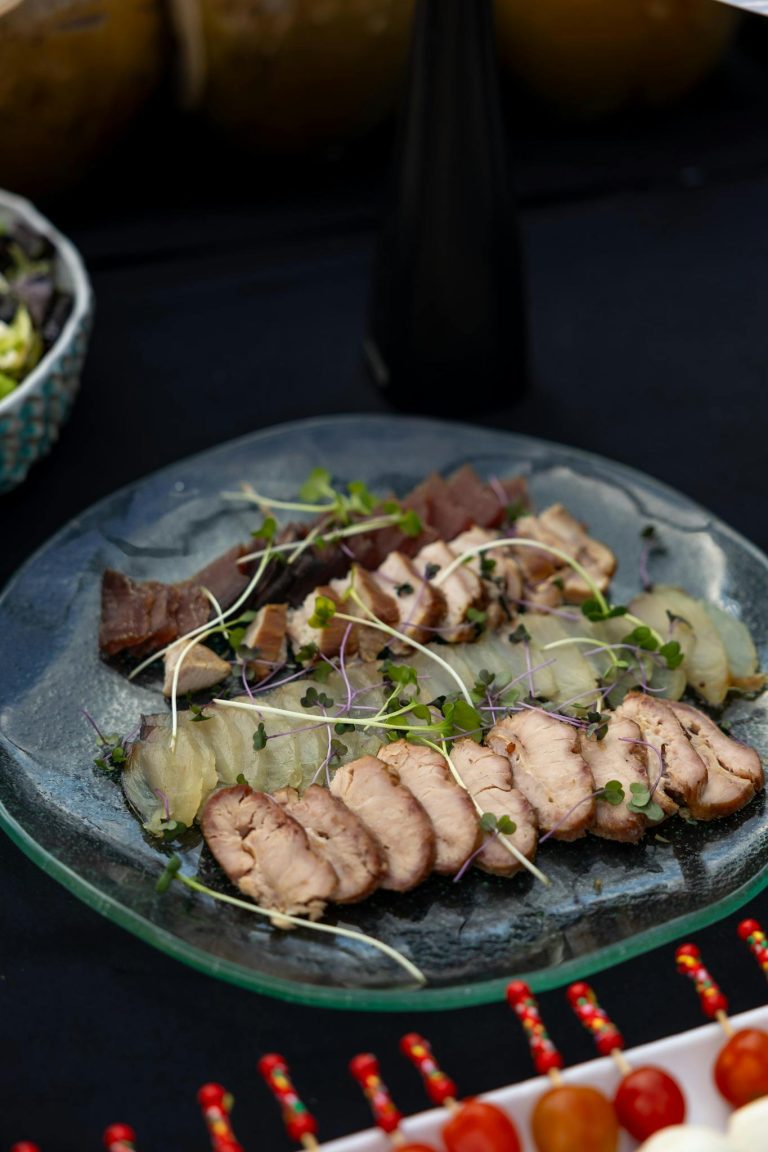 Plate with assorted smoked meats and microgreens, perfect for gourmet dining.